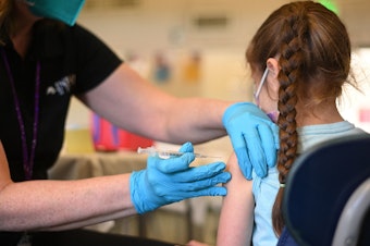 caption: A nurse administers a pediatric dose of the Covid-19 vaccine to a girl at a L.A. Care Health Plan vaccination clinic at Los Angeles Mission College in the Sylmar neighborhood in Los Angeles, Ca., January 19, 2022.