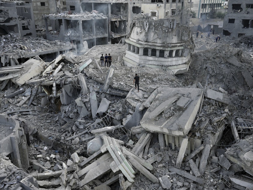 caption: Palestinians inspect the rubble of the Yassin Mosque, destroyed after it was hit by an Israeli airstrike at Shati refugee camp in Gaza City, early Monday. Israel's military battled to drive Hamas fighters out of southern towns and seal its borders Monday as it pounded the Gaza Strip.