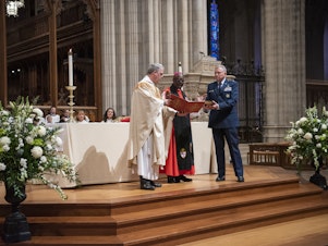 caption: The Rev. Randolph Hollerith, dean of the Washington National Cathedral (from left); the Rev. Carl Wright, the Episcopal Church's bishop suffragan for the armed forces; and Maj. Gen. Steven Schaick, the Air Force chief of chaplains, participate in the blessing of a Bible for swearing in U.S. Space Force officials.