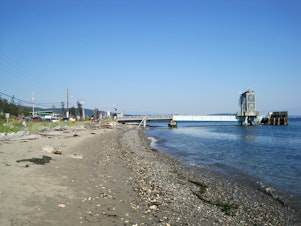 caption: View of the Guemes Island ferry dock from the beach. The Guemes Island ferry is Skagit County's only ferry, with 20 runs a day. 