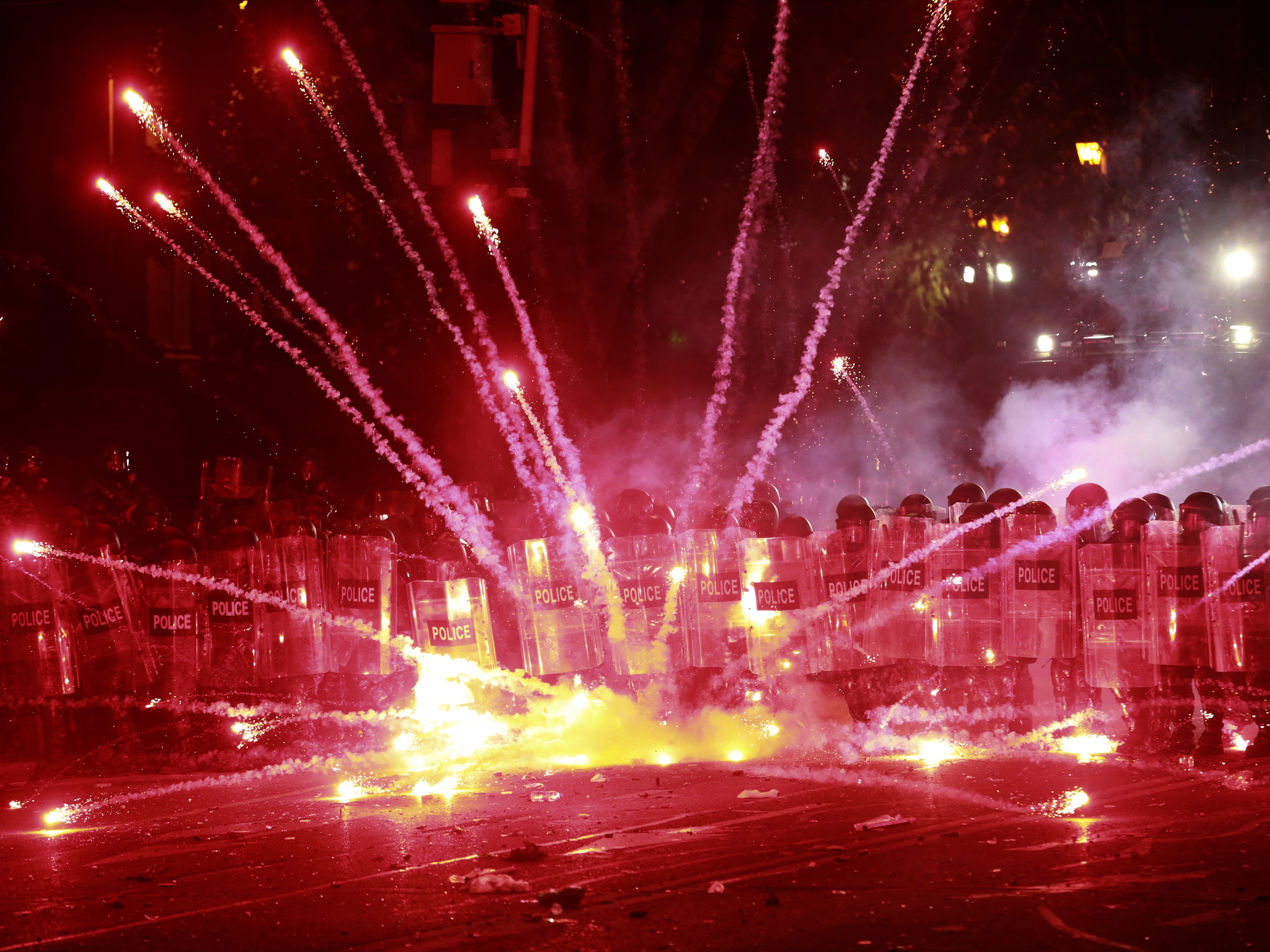 caption: Demonstrators use firecrackers against police during a rally against the government's decision to suspend negotiations on joining the European Union for four years, outside the parliament's building in Tbilisi, Georgia, early Sunday, Dec. 1, 2024.