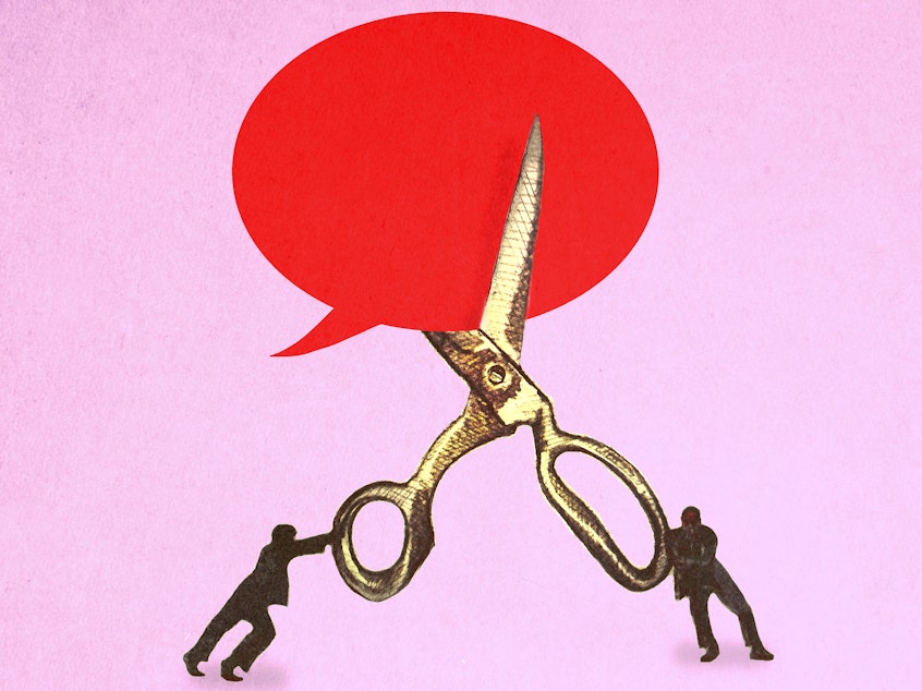 Illustration of two people in silhouette holding larger-than-life scissors and cutting a giant blank speech bubble in half.
