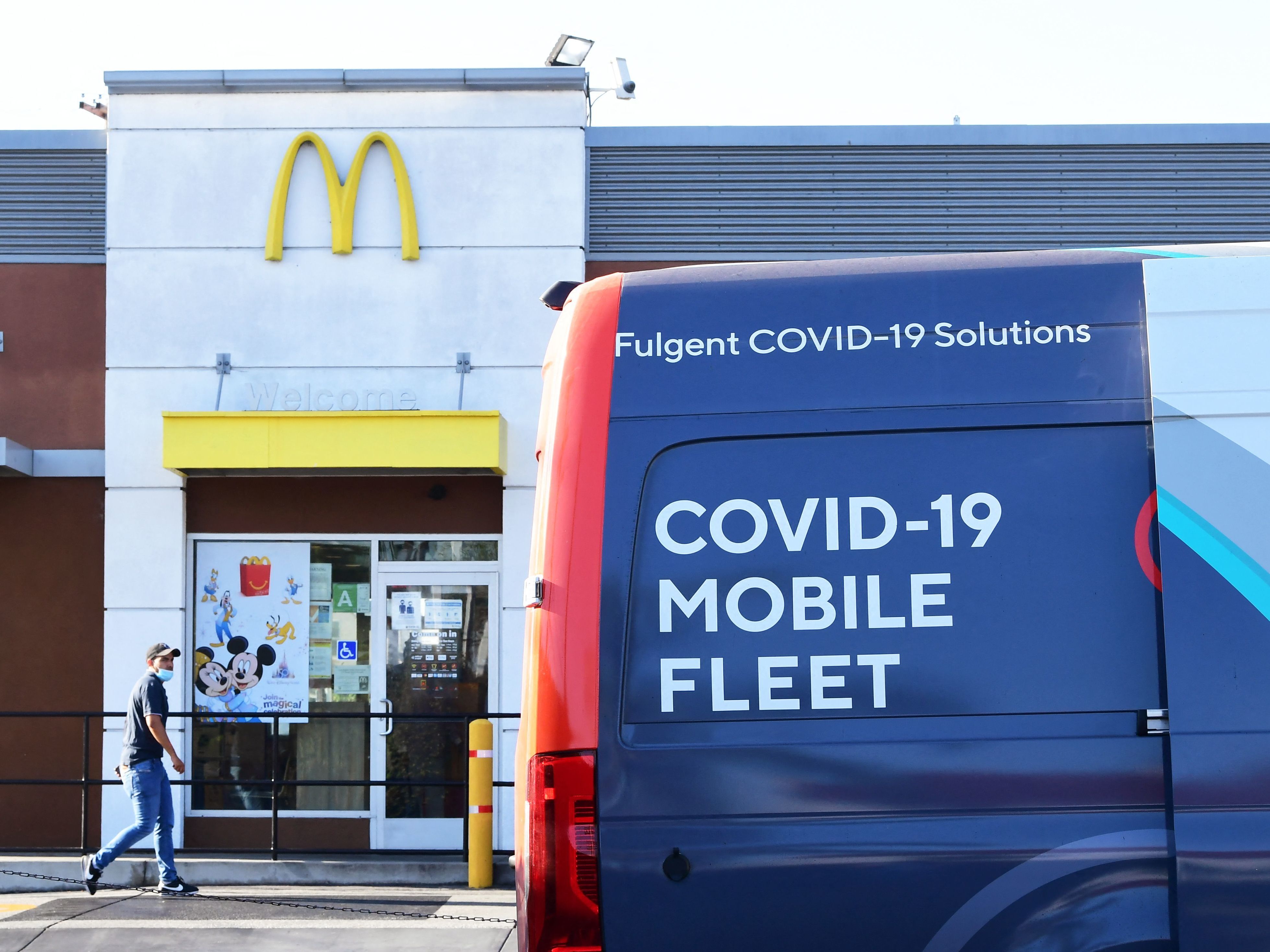 caption: A man approaches a van from a COVID-19 vaccine mobile clinic hosted by McDonald's and the California Department of the Public Health in September in Los Angeles.