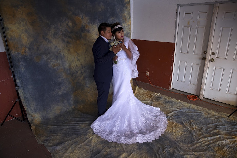 caption: Argimiro Nuñez and Honorina Hernandez pose for a portrait for their wedding photographer before a mass wedding ceremony where they were married along with 22 other couples on Sunday, June 2, 2019, at Our Lady of the Desert Church in Mattawa. 