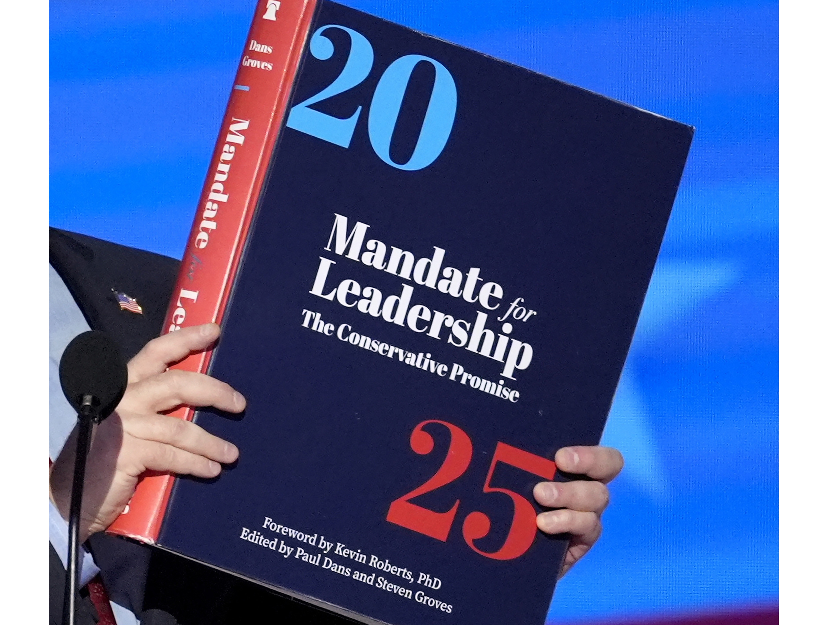 caption: A copy of Project 2025 is held during the Democratic National Convention in August.