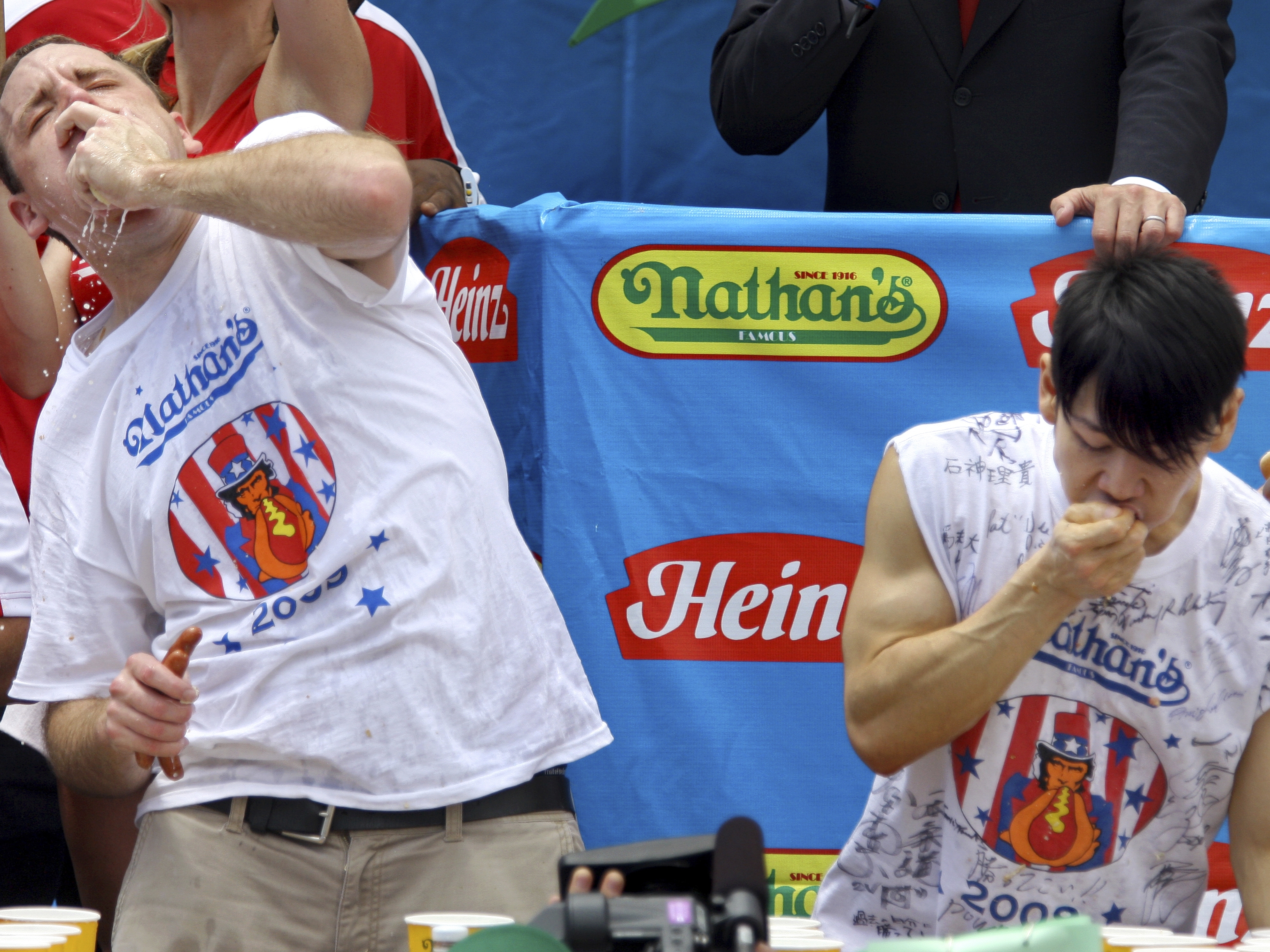 caption: Joey Chestnut (L) and Takeru Kobayashi (R) compete in the Nathan's hot dog-eating contest on July 4, 2009, in New York. 