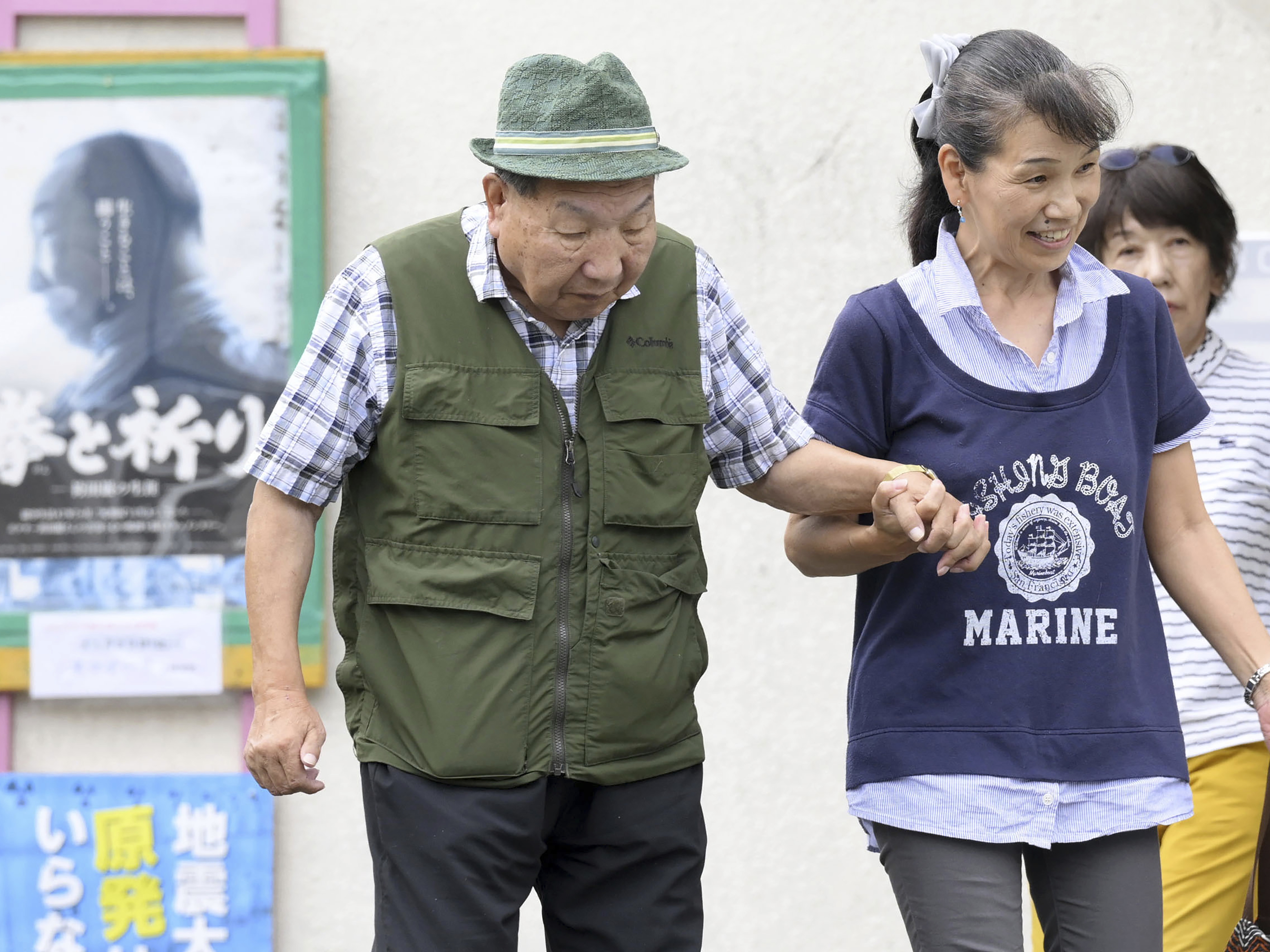 caption: Iwao Hakamada, left, is helped by a supporter as he goes for a walk in Hamamatsu, Shizuoka prefecture, central Japan on Wednesday.