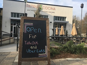 caption: Patria Cocina's indoor and outdoor seating is closed for the time being, but delivery drivers stay busy amidst the coronavirus pandemic.