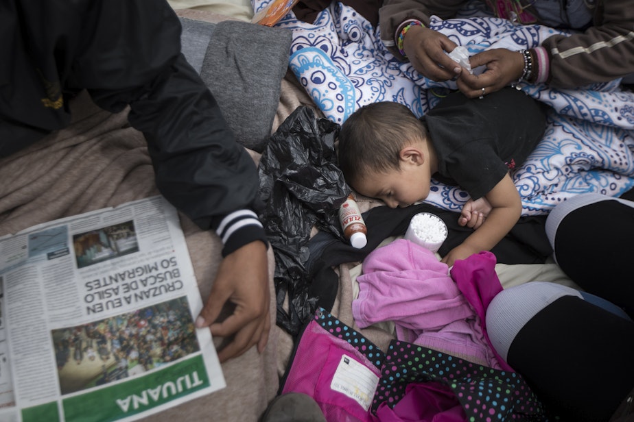 caption: A two-year-old child from Honduras gets treatment for an ear infection after sleeping in the open in front of the El Chaparral port of entry, in Tijuana, Mexico, Monday, April 30, 2018. 