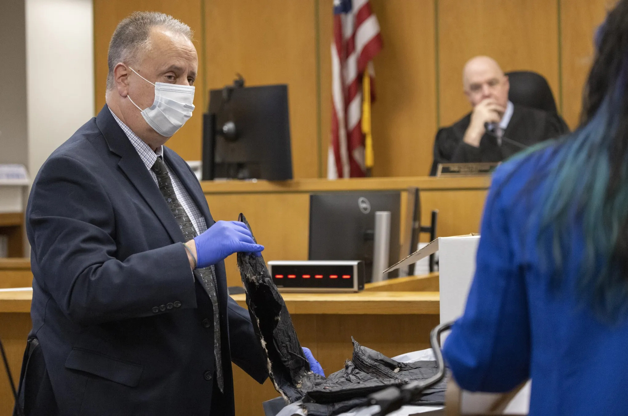 caption: Seattle police Detective Alan Cruise shows evidence collected at the scene when medics were trying to save the life of Antonio Mays Jr. and another boy, on the third day of the Mays vs. City of Seattle trial, Monday, Dec. 15. Antonio Mays Jr. was shot and killed in CHOP in 2020.