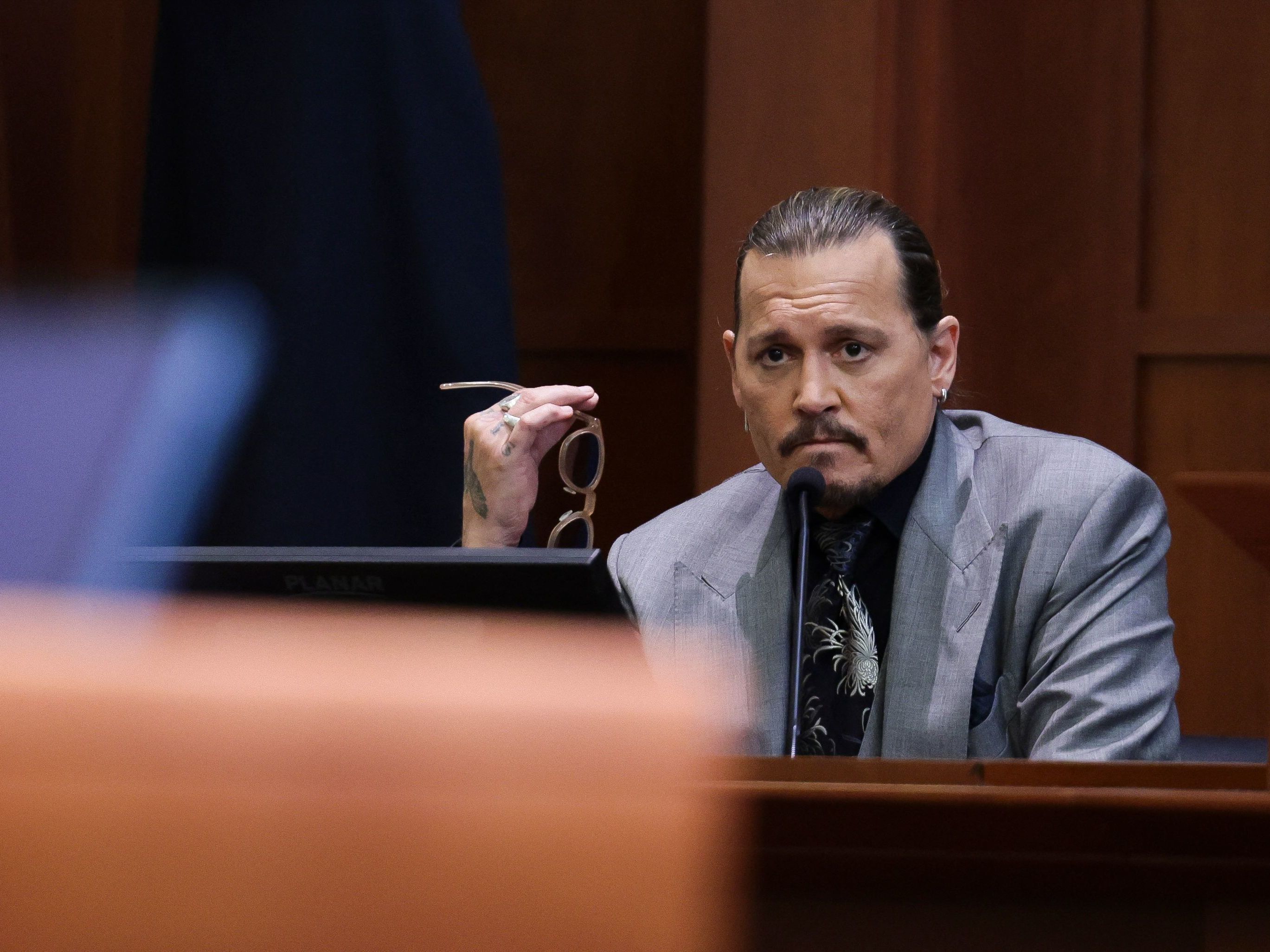caption: Actor Johnny Depp looks on at the end of the second day of his testimony during the defamation trial against his ex-wife Amber Heard, at the Fairfax County Circuit Courthouse in Fairfax, Va., on Wednesday.