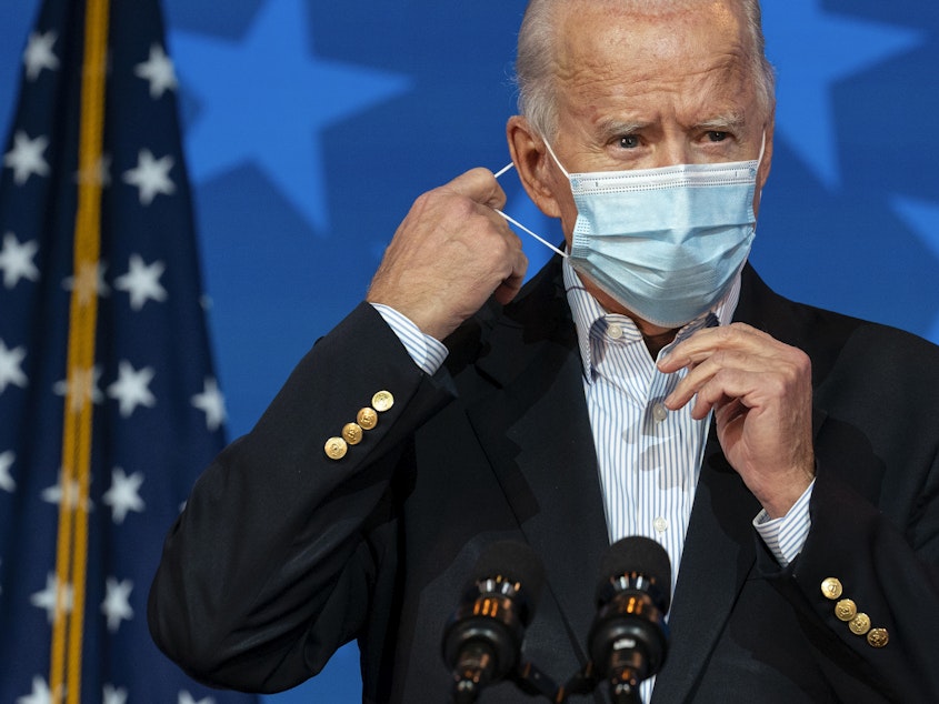 caption: Joe Biden, now the president-elect, removes his face mask Thursday to speak in Wilmington, Del. When he takes office, Biden will be dealing with a virus that is rampaging through the country.