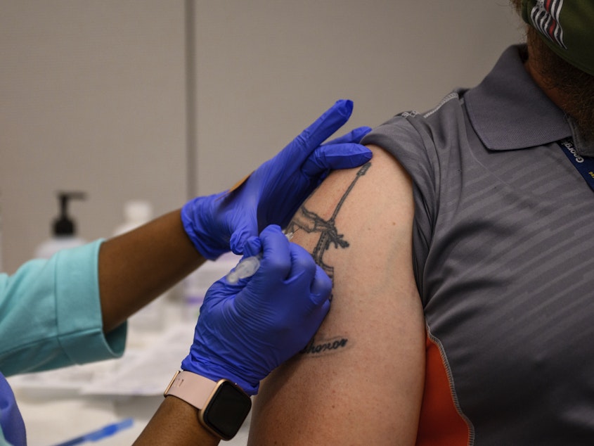 caption: A Georgia Tech employee receives a Pfizer coronavirus vaccination on the campus April 8. For a number of Americans, getting their shots is as easy as showing up to their workplace as some companies and institutions provide on-site vaccinations to their employees.