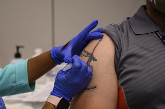 caption: A Georgia Tech employee receives a Pfizer coronavirus vaccination on the campus April 8. For a number of Americans, getting their shots is as easy as showing up to their workplace as some companies and institutions provide on-site vaccinations to their employees.
