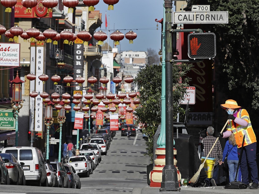 caption: In this Jan. 31, 2020, file photo, a masked worker cleans a street in the Chinatown district in San Francisco. Police and volunteers have increased their street presence after a series of violent attacks against older Asian residents in Bay Area cities stoked fear and subdued the celebratory mood leading up to the Lunar New Year. (AP Photo/Ben Margot, File)
