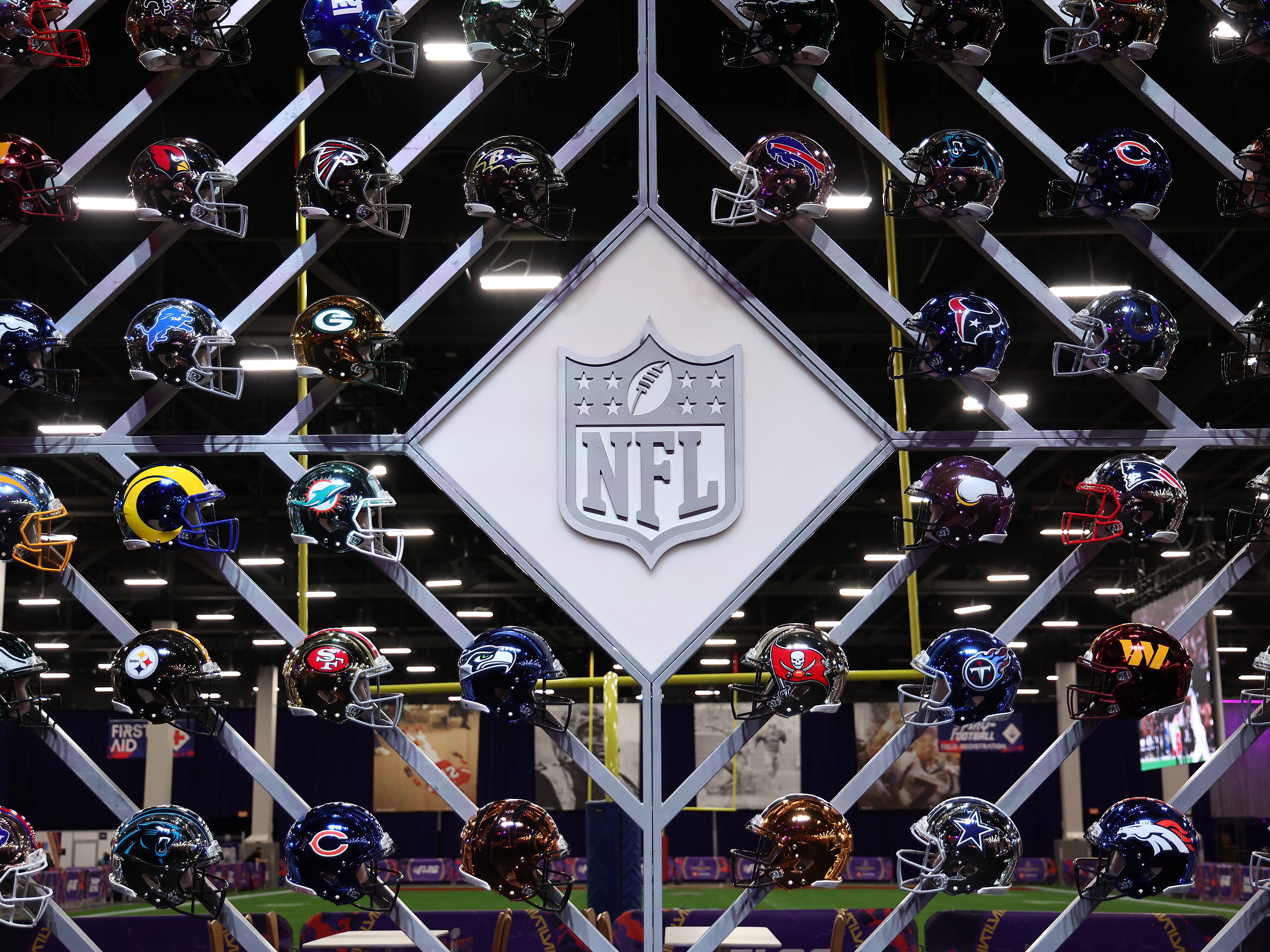 caption: The NFL logo is surrounded by helmets of the 32 teams in the league. A new survey released Monday found that a third of former NFL players believe they have CTE, a degenerative brain disease linked to concussions.