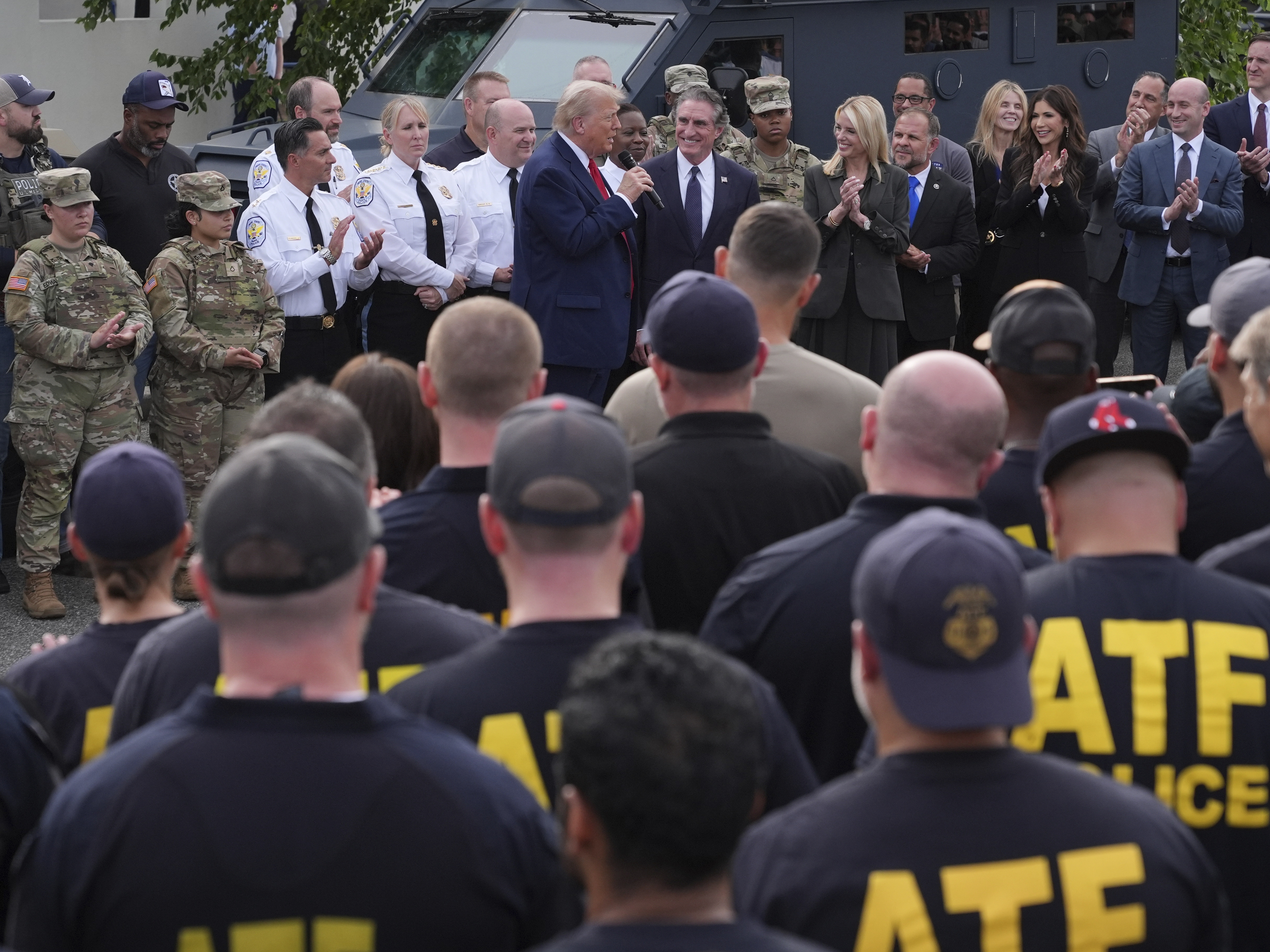 caption: President Donald Trump speaks with members of law enforcement and National Guard soldiers on Aug. 21, 2025, in Washington.