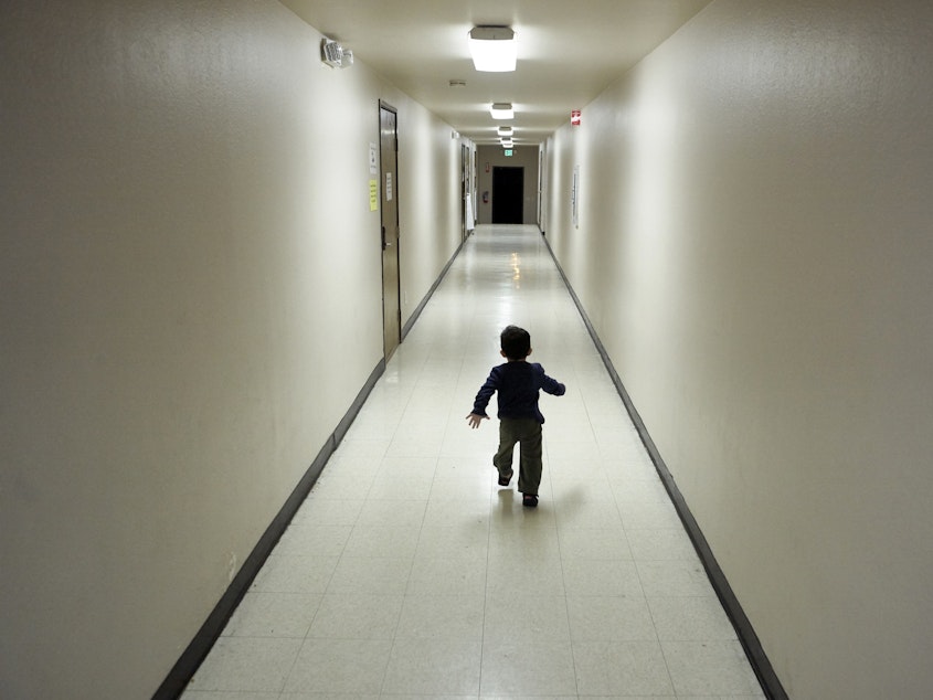 caption: An asylum-seeking boy from Central America runs down a hallway in December after arriving at a shelter in San Diego. Immigrant advocates say they are suing the U.S. government for allegedly detaining immigrant children too long and improperly refusing to release them to relatives.