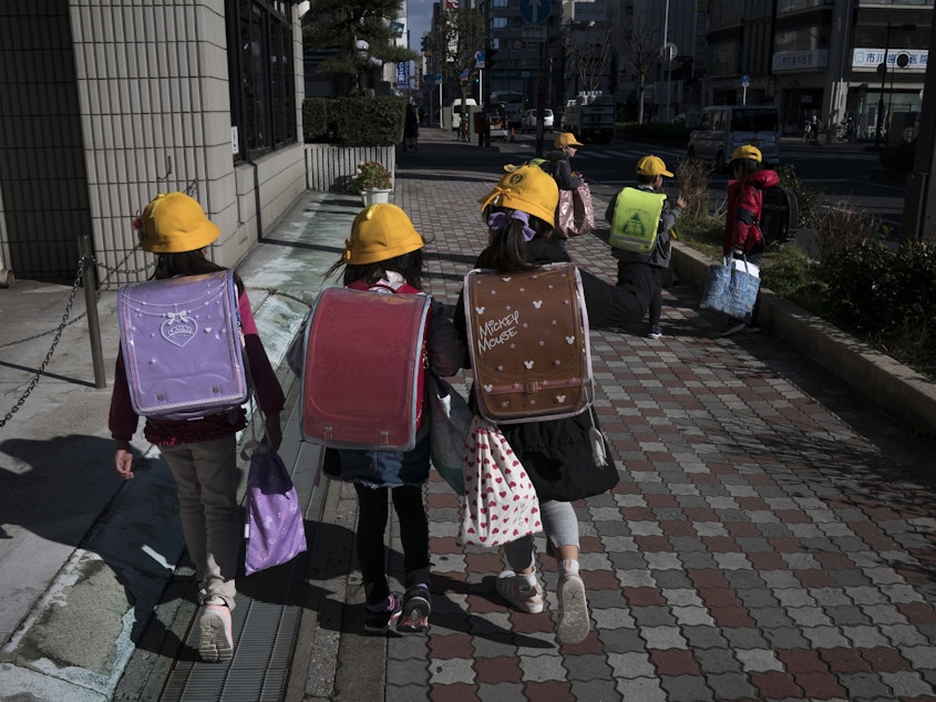 caption: Japan is asking all schools from the elementary to high school level to shut down for the next month, citing the risk of spreading the COVID-19 coronavirus. Here, elementary school students head home Thursday in Ichikawa, Japan.