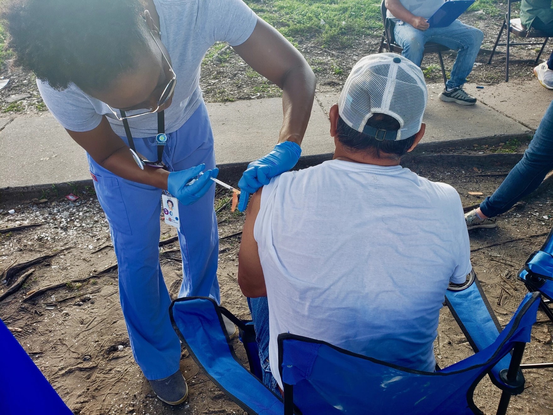 caption: Physician assistant Danis Walker vaccinates a construction worker outside a Lowes Home Improvement store in New Orleans on June 11, 2021.
