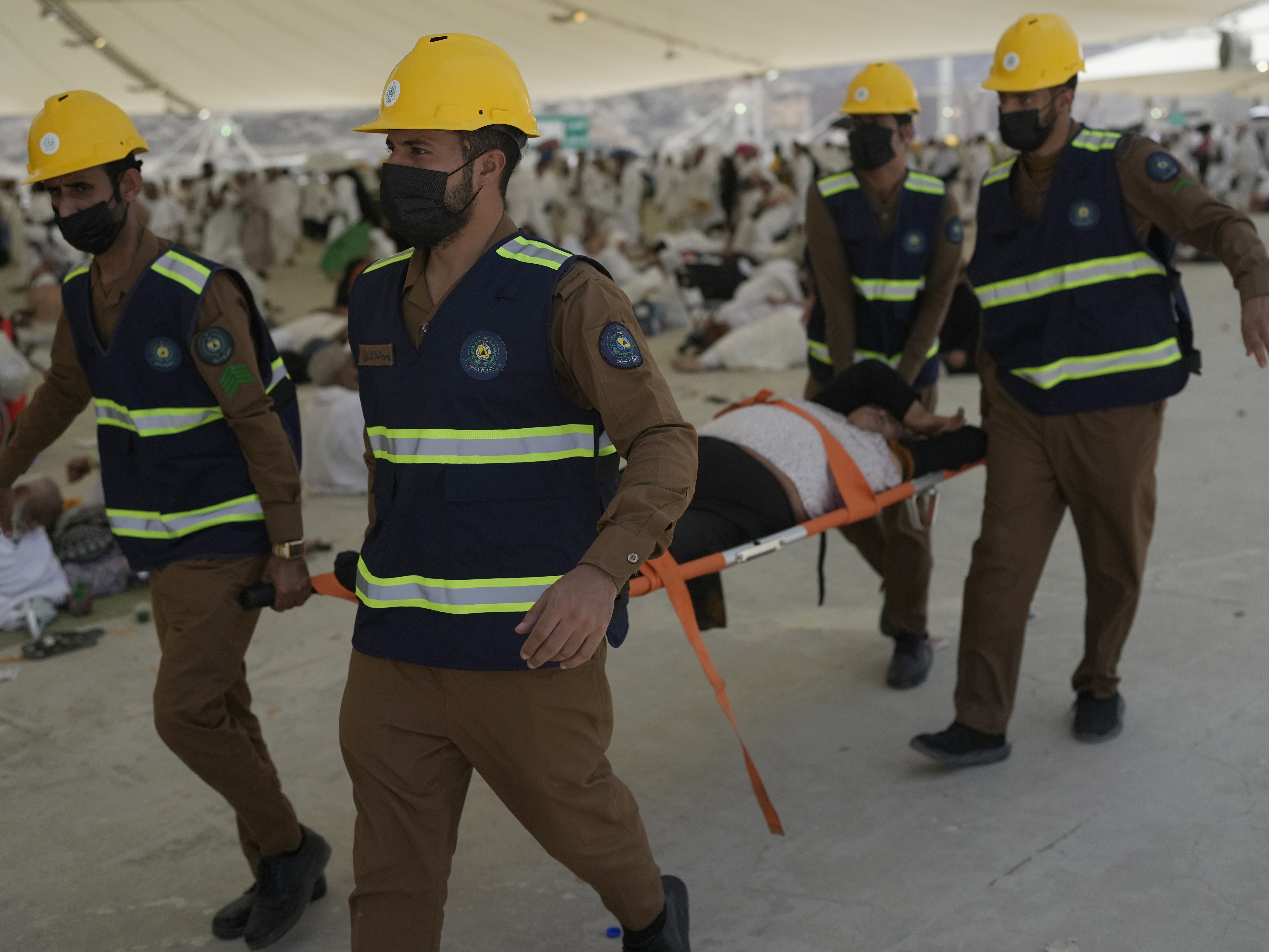 caption: Paramedics carry a Muslim pilgrim for a medical check after he fell down due to a heat stroke near the holy city of Mecca, Saudi Arabia, on Sunday, June 16, 2024. Masses of pilgrims on Sunday embarked on a symbolic stoning of the devil in Saudi Arabia, which marks the final days of the Hajj, or Islamic pilgrimage, and the start of the Eid al-Adha celebrations for Muslims around the world.