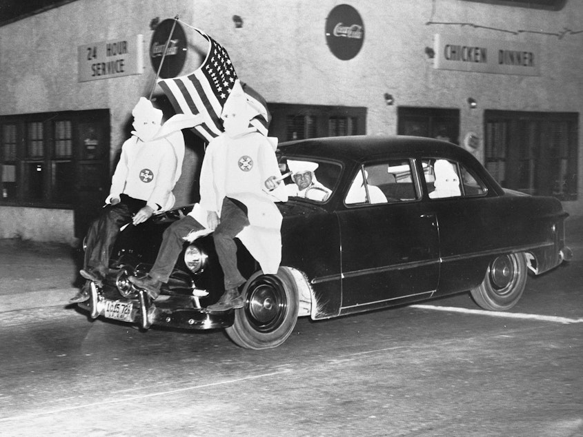 caption: In 1949, Ku Klux Klan members ride down the street in Gadsden, Ala., as part of an 18-car parade.