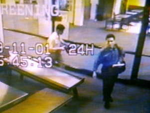 caption: Two men identified by authorities as suspected hijackers Mohammed Atta (right) and Abdulaziz Alomari (center) pass through airport security Sept. 11, 2001 at Portland International Jetport in Maine in an image from airport surveillance tape released Sept. 19, 2001.