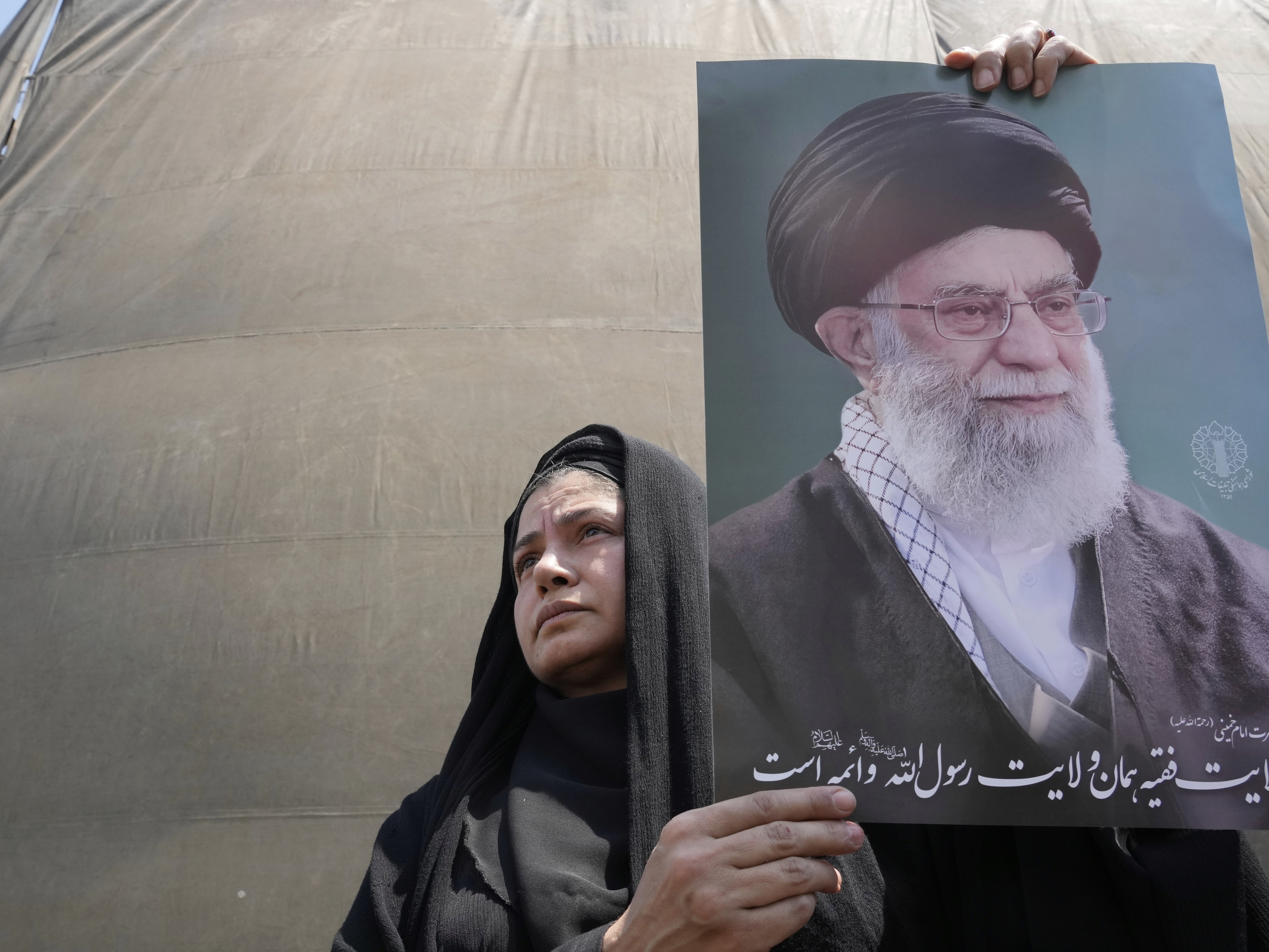 caption: An Iranian protester holds up a poster of the Supreme Leader Ayatollah Ali Khamenei in an anti-Israeli gathering in Tehran, Iran, June 13.