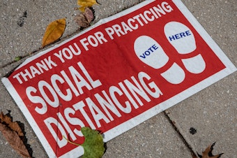 caption: A social distancing sign on the ground. "Social distancing" was one of dozens of terms highlighted by researchers in Oxford Languages' 2020 Word of the Year campaign.