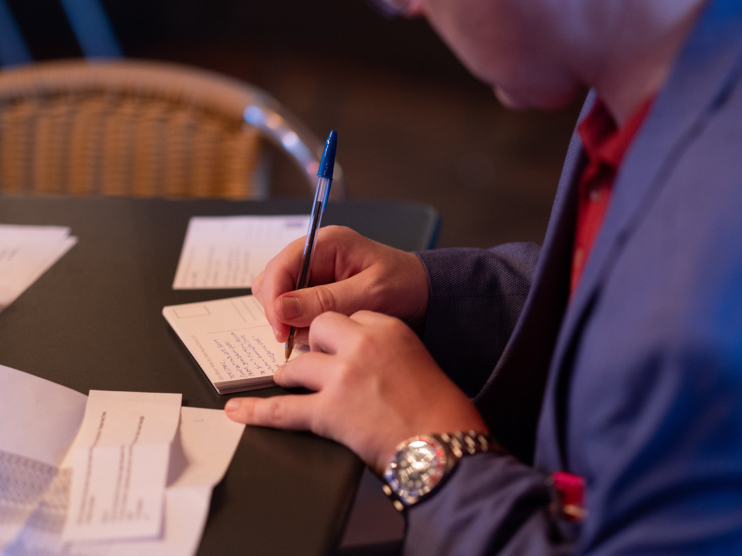 caption: A member of the Young Republicans fills out a postcard asking for support for GOP candidates in Georgia.