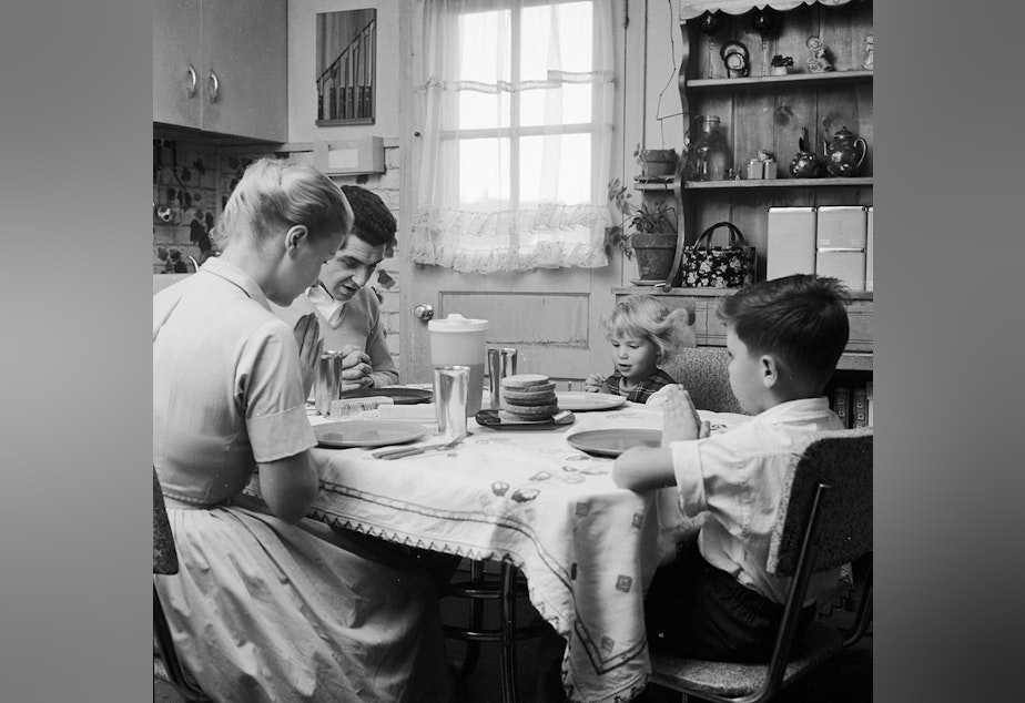 caption: Mr. and Mrs. Paul, and their children Belinda and Cliff, say grace before starting their meal.  (Jacobsen /Three Lions/Getty Images)
