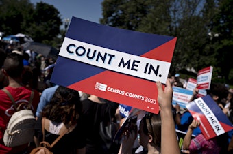 caption: A demonstrator holds a sign that reads "Count Me In" outside the U.S. Supreme Court in 2019. Sen. Brian Schatz, D-Hawaii, has introduced companion legislation to a House bill that could help prevent political interference with future head counts.