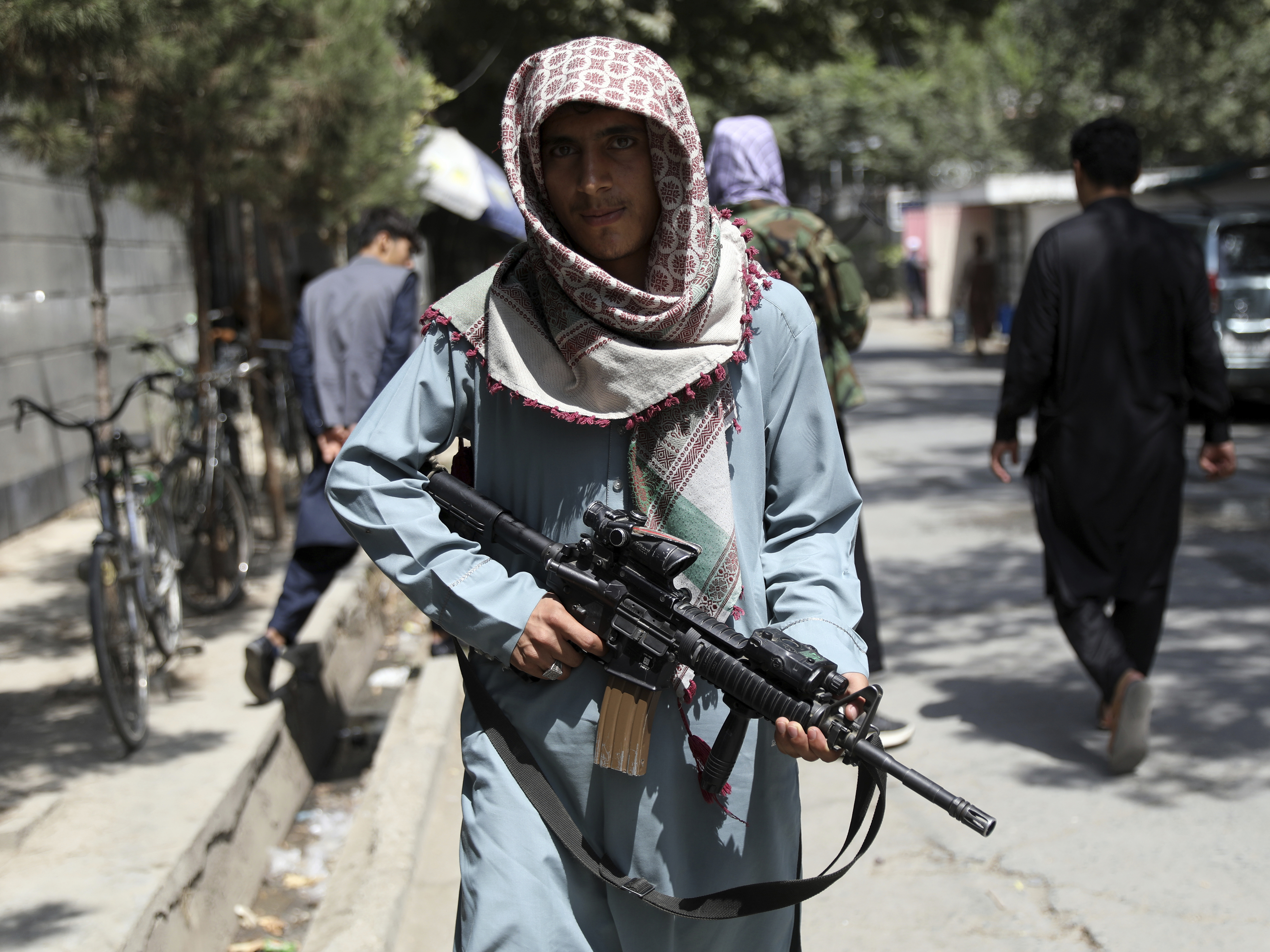 caption: A Taliban fighter stands guard at a checkpoint in the Wazir Akbar Khan neighborhood in the city of Kabul, Afghanistan, on Sunday.
