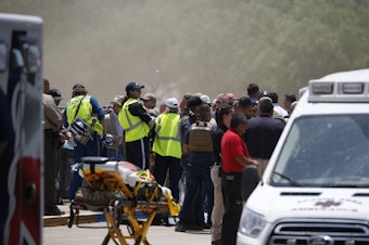 caption: Emergency personnel gather near Robb Elementary School following a shooting Tuesday, May 24, 2022, in Uvalde, Texas. Nineteen children and two adults were shot and killed.