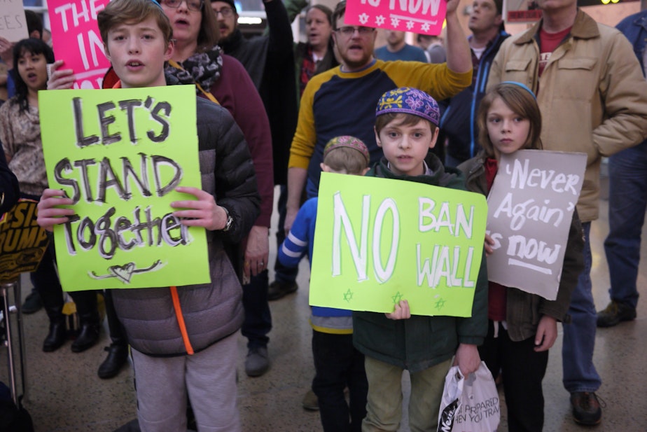 caption: Jewish children protest the so-called Muslim travel ban at Sea-Tac International Airport.