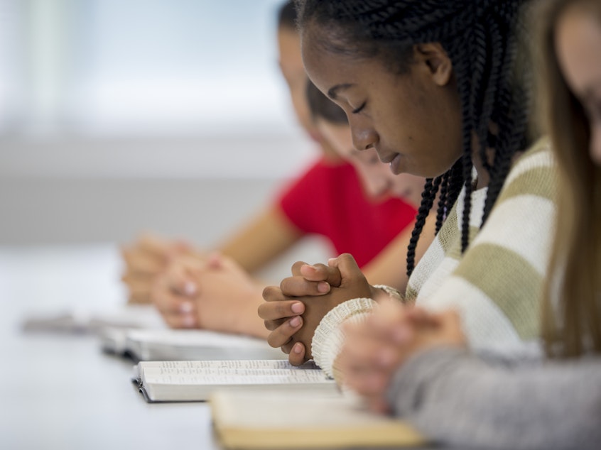 caption: New guidance from the Department of Education says a school may take reasonable measures to ensure students aren't pressured to join in their teachers' or coaches' prayers.