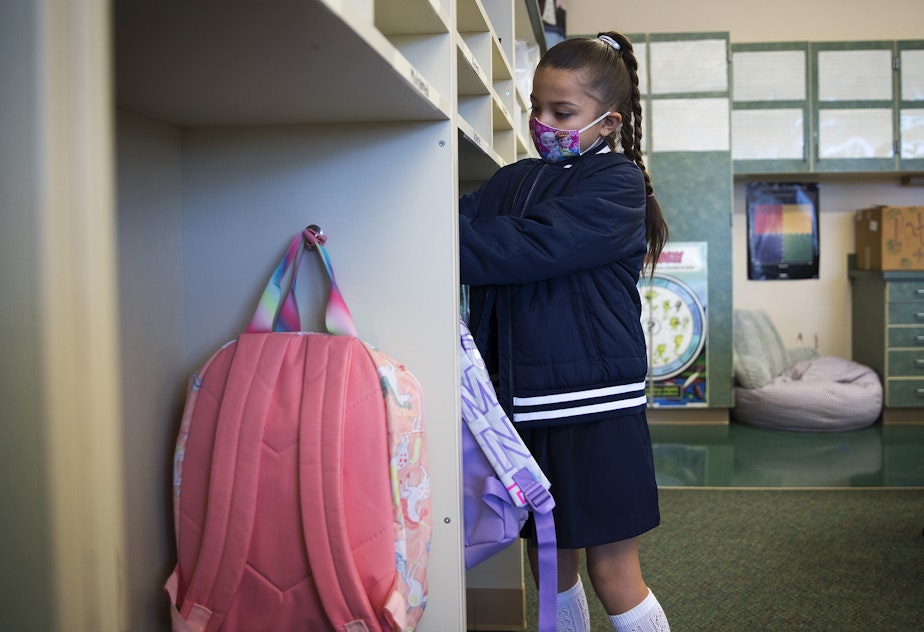 caption: Ximena Vaca Torres, 8, puts away her backpack on her first day of 3rd grade at Mount View Elementary school on Thursday, September 2, 2021, in Seattle.