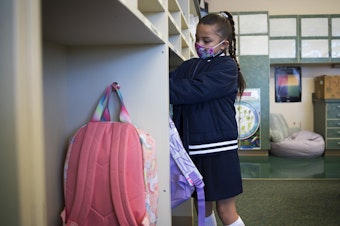 caption: Ximena Vaca Torres, 8, puts away her backpack on her first day of 3rd grade at Mount View Elementary school on Thursday, September 2, 2021, in Seattle.
