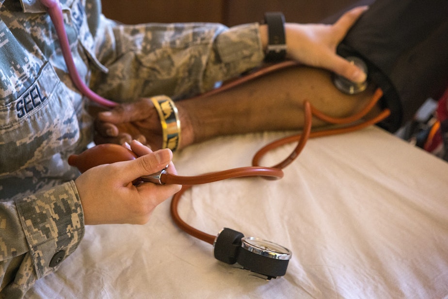 caption: A New Jersey Air National Guard member checks the blood pressure of a homeless veteran