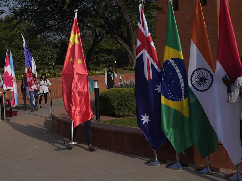 caption: A worker carries a Chinese national flag to put it with those of other participating countries at the opening session of the G-20 foreign ministers meeting in New Delhi on March 2.
