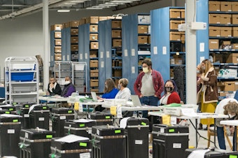 caption: Gwinnett County election workers prepare to handle ballots as part of the recount for the 2020 presidential election on Nov. 16, 2020, in Lawrenceville, Georgia. Nearly two and a half years after the election, voting machine companies, election workers and even a local postmaster have filed defamation cases tied to conspiracy theories that have spread about the election.