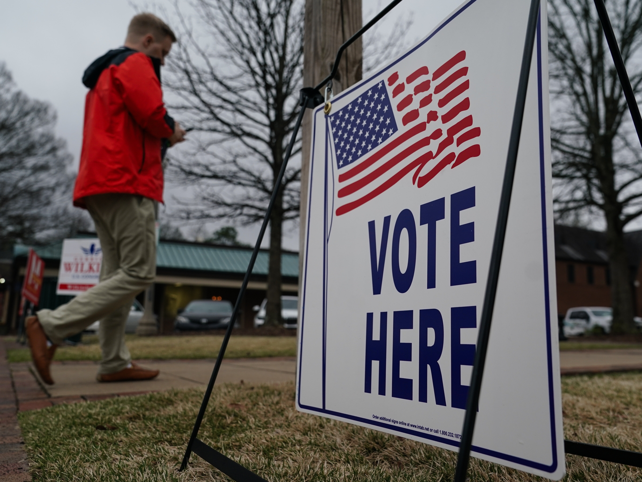 caption: A voter walks toward a polling place to cast their ballot for Alabama’s March primary election in Mountain Brook, Ala.