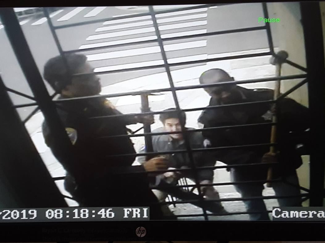 caption: A still from a surveillance camera at the home of Bryan Carmody, which was raided by San Francisco police on Friday.