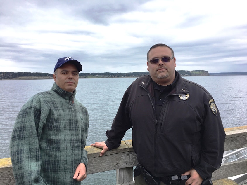 caption: Fred Farris, the father of Keaton Farris, and Island County Jail Chief Jose Briones pose together on the Coupeville Wharf.