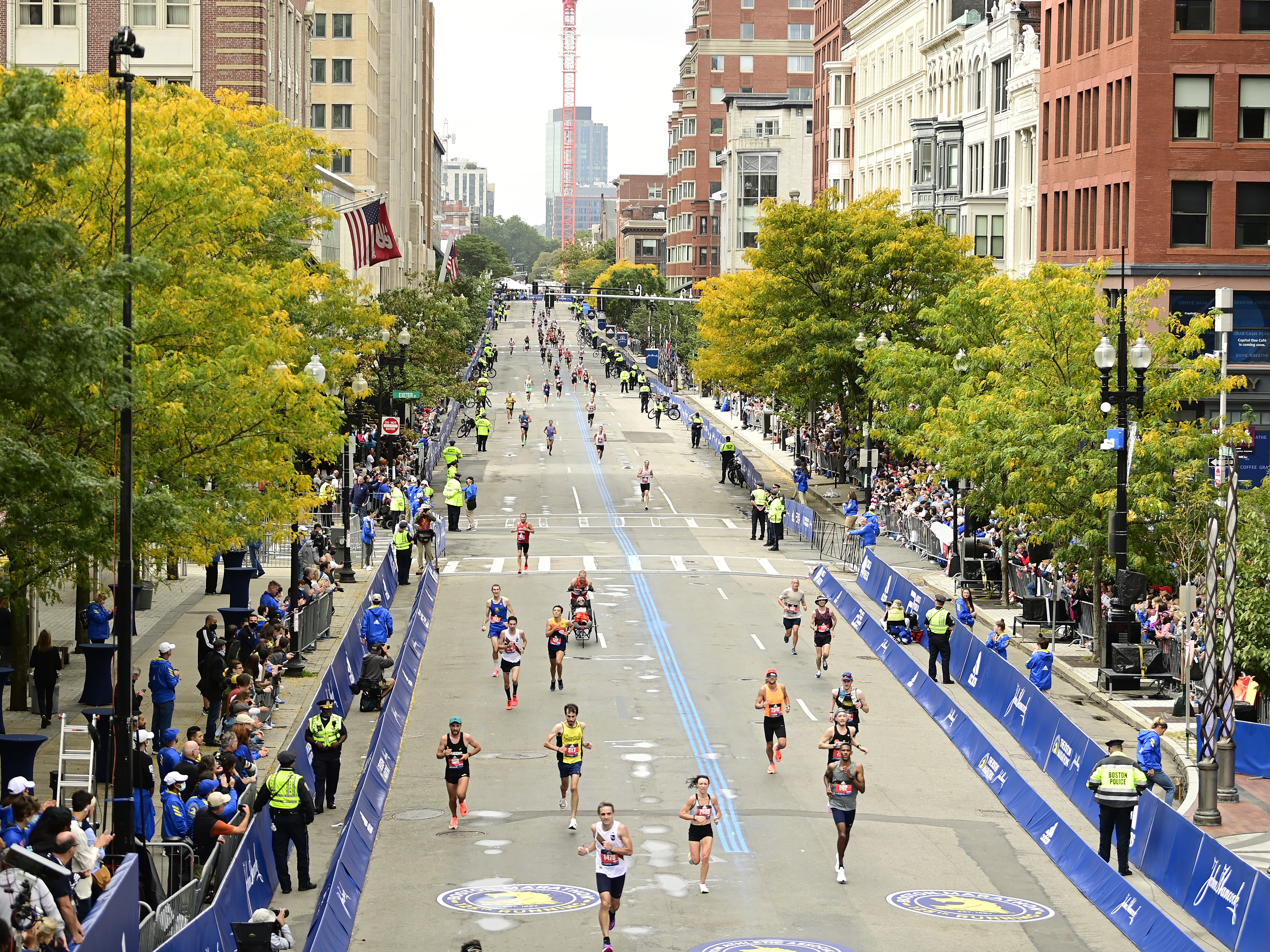 caption: Runners near the finish line on Boylston Street during the 125th Boston Marathon on October 11, 2021 in Boston, Massachusetts. Runners residing in Russia and Belarus are banned from this year's event.