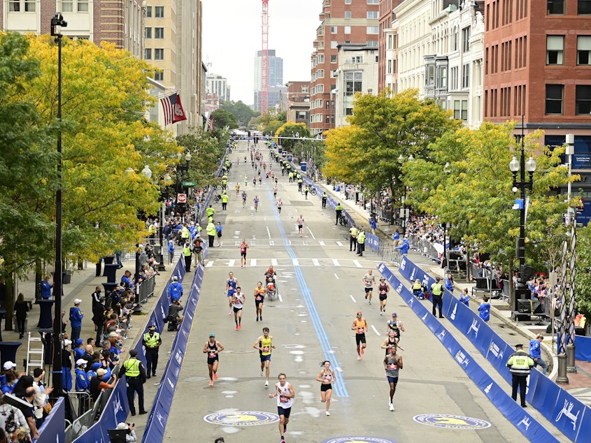 caption: Runners near the finish line on Boylston Street during the 125th Boston Marathon on October 11, 2021 in Boston, Massachusetts. Runners residing in Russia and Belarus are banned from this year's event.