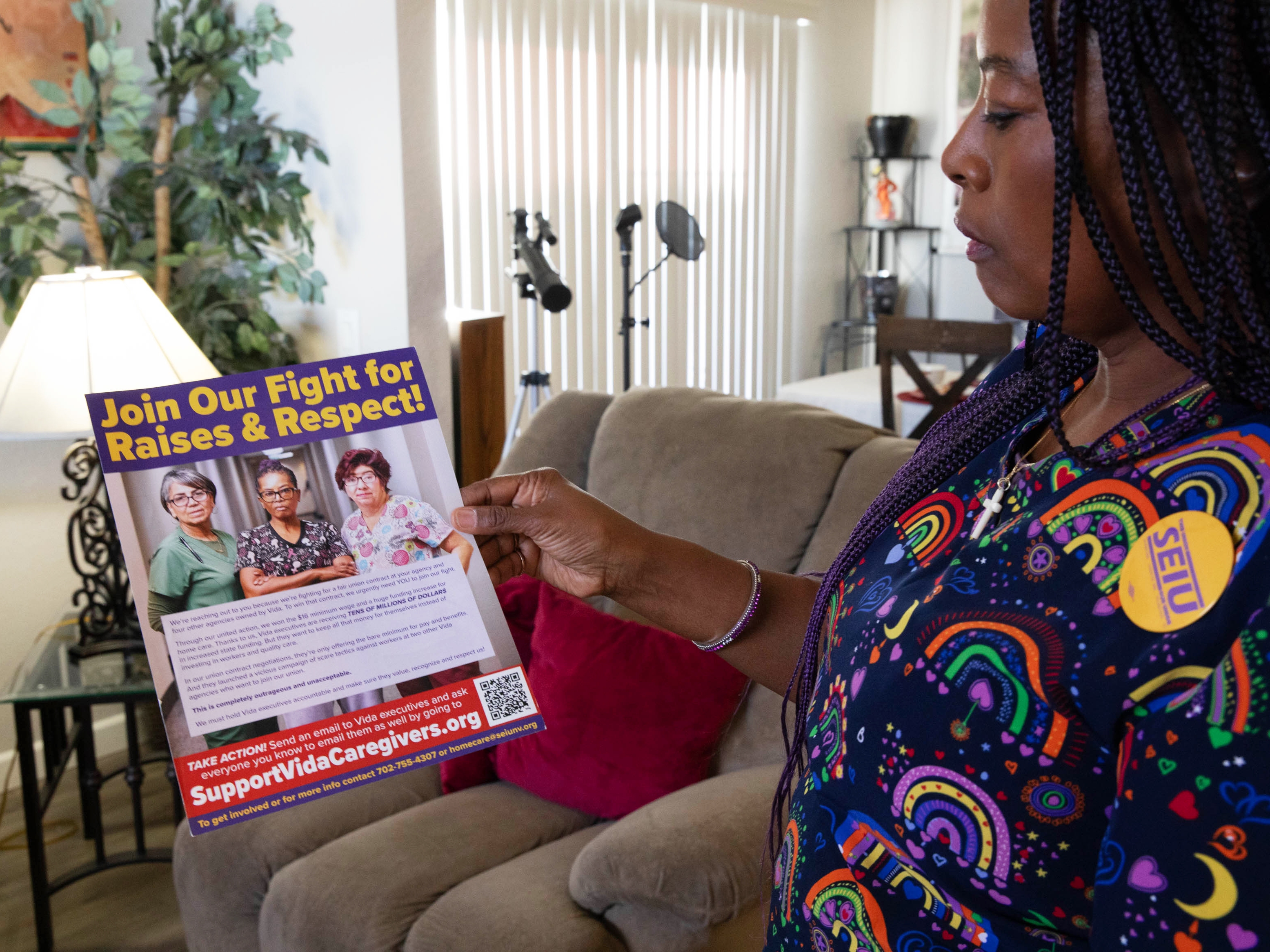 caption: Regina Brown-Ross, a home care worker and union organizer with SEIU Local 1107, looks at a union flier at her home in Las Vegas.