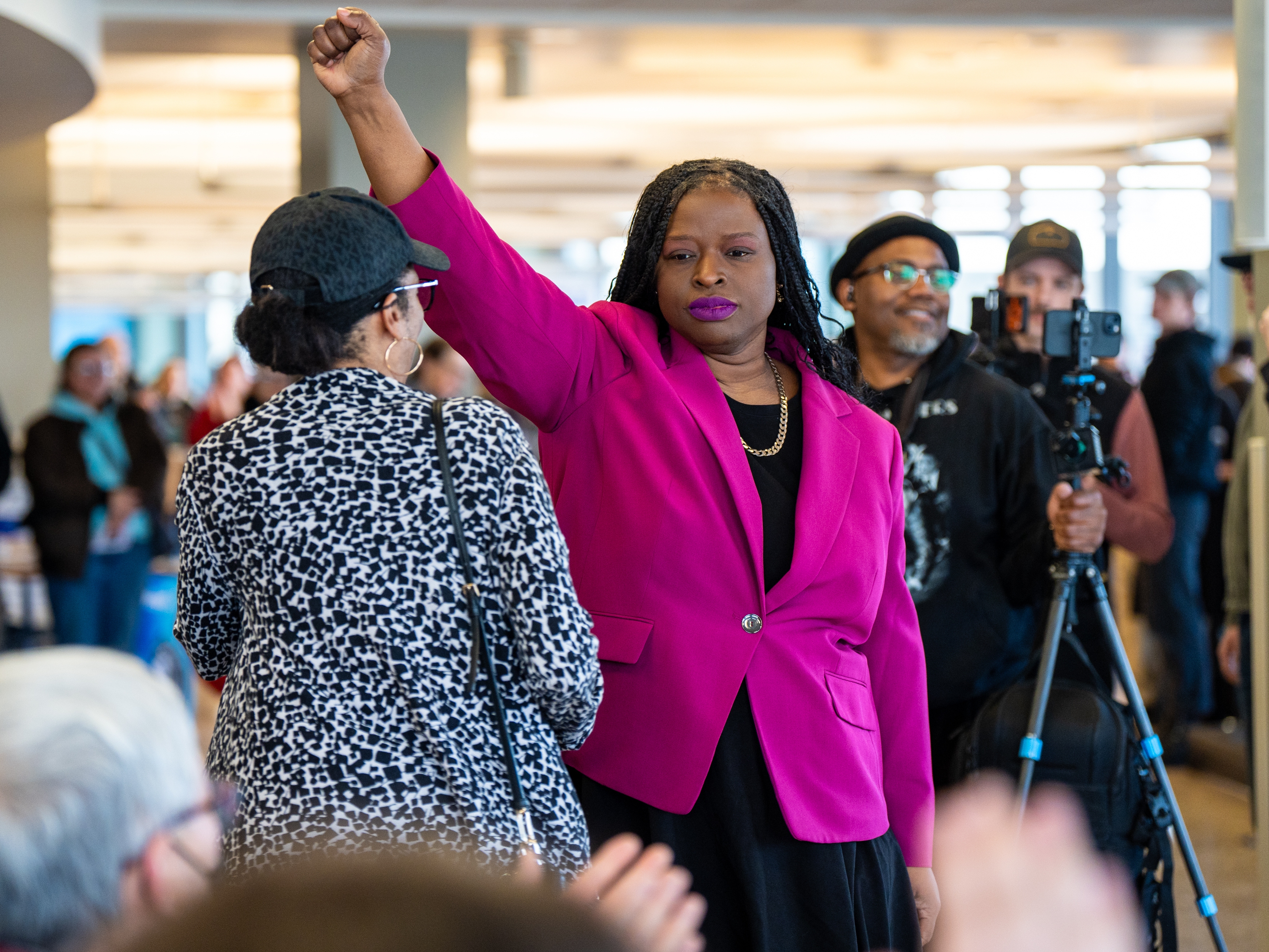 caption: Nekima Levy Armstrong holds up her fist after speaking at an anti-ICE rally for Martin Luther King Jr. on Jan. 19 in St. Paul, Minn.