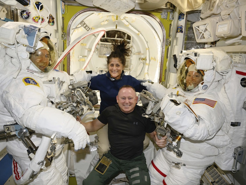 caption: Boeing crew flight test astronauts Suni Williams and Butch Wilmore, center, pose with Expedition 71 flight engineers Mike Barratt, left, and Tracy Dyson, both NASA astronauts, in their spacesuits aboard the International Space Station's Quest airlock on June 24, 2024.