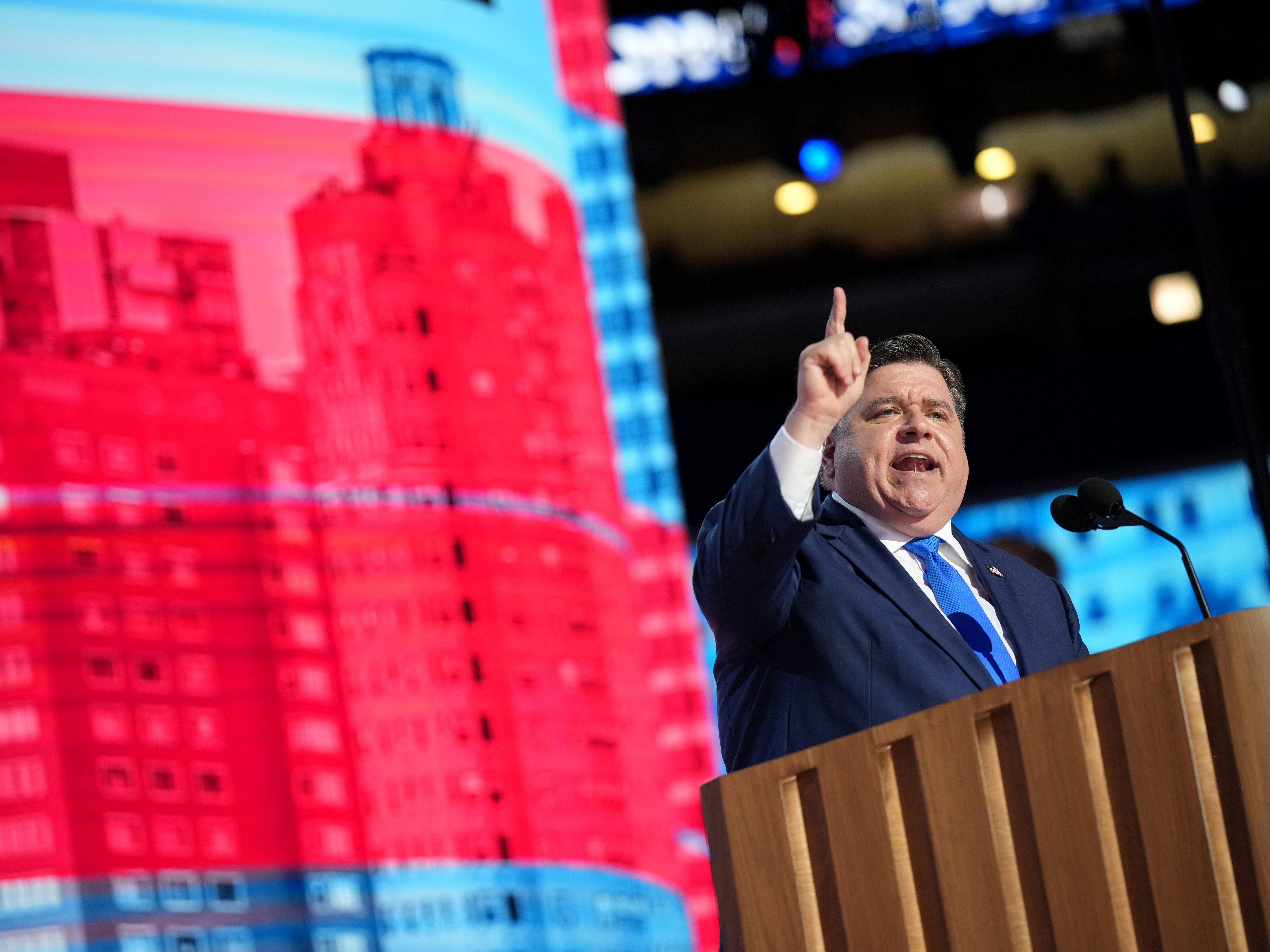 caption: Illinois Gov. J.B. Pritzker speaks on stage during the second day of the Democratic National Convention in Chicago, Illinois.